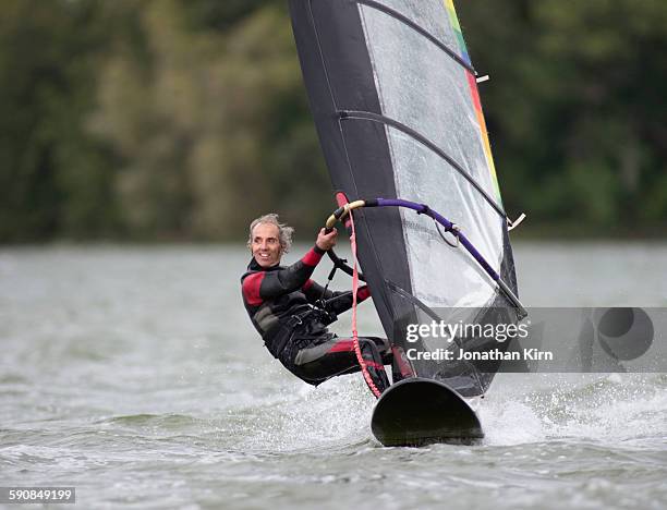 eighty-year old wind surfer. - wind surfing stock pictures, royalty-free photos & images