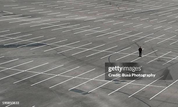 a man standing in the middle of a parking lot - valet stock-fotos und bilder