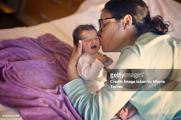 mum kissing newborn at hospital - home birth 個照片及圖片檔