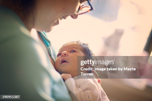 Mom smiling at newborn at hospital Mom smiling at newborn at hospital