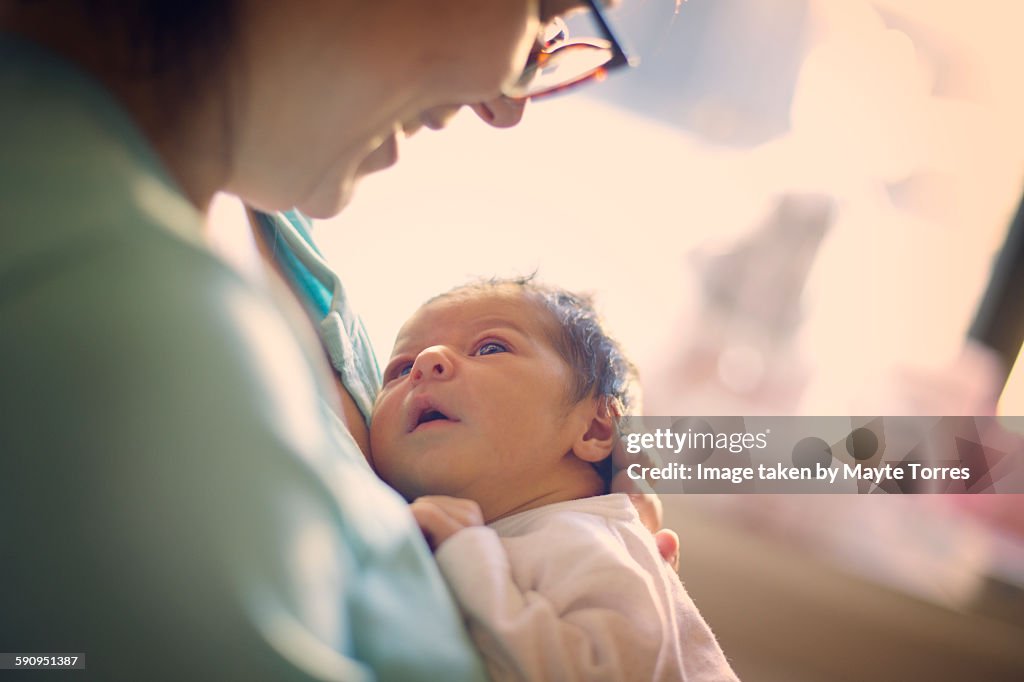 Mom smiling at newborn at hospital