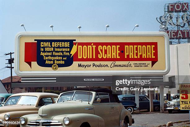 Civil Defense Billboard with old cars in front