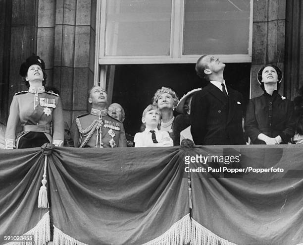 The British Royal Family look up from the balcony of Buckingham Palace to view a fly past of Royal Air Force planes following the trooping of the...