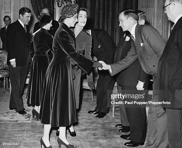 Queen Elizabeth II , Princess Margaret and Royal fashion designer Norman Hartnell are greeted on their arrival at a fashion show by the Incorporated...