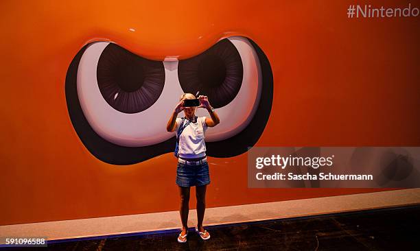 Visitor makes a selfie in front of the Nintendo stand at the Gamescom 2016 gaming trade fair during the media day on August 17, 2016 in Cologne,...