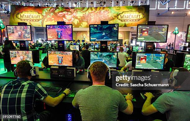 Visitors try out the massively multiplayer online role-playing game 'World Of Warcraft' at the Blizzard Entertainment stand at the Gamescom 2016...