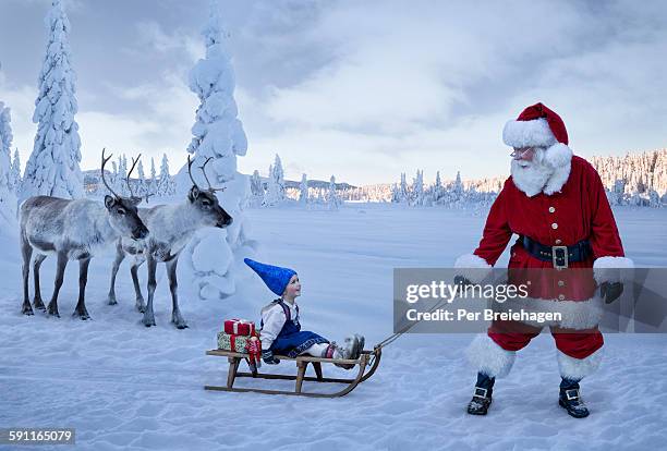 santa claus pulling a girl on sled with reindeer - father christmas and elves stock pictures, royalty-free photos & images