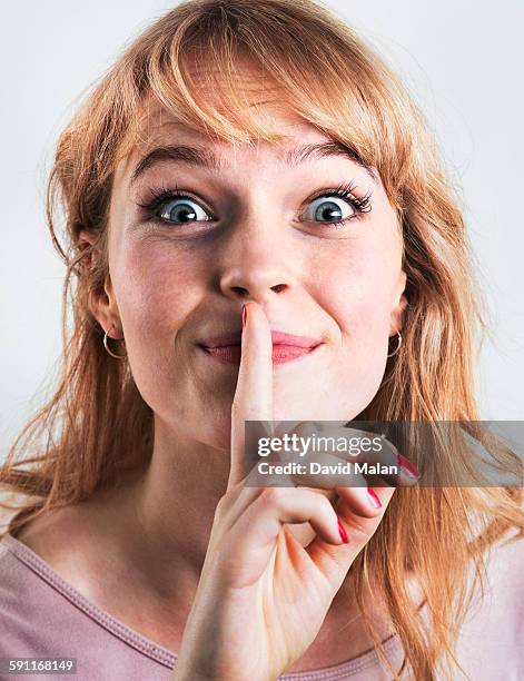 blonde woman holding a finger to her lips - woman with finger on lips stock pictures, royalty-free photos & images