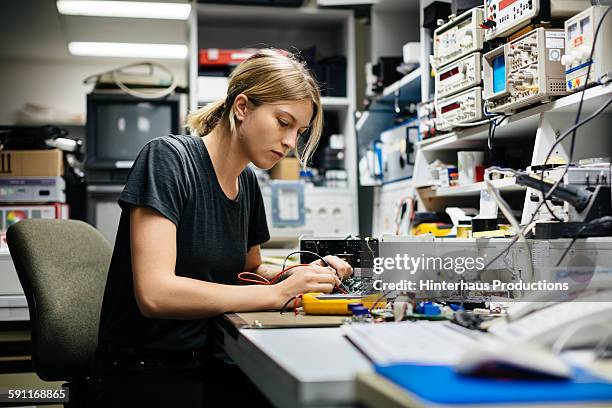 female engineer measuring voltage - hora del día fotografías e imágenes de stock