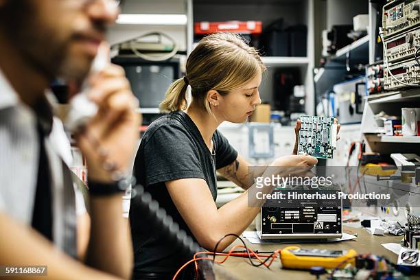 female technician working on conductor board - elektronik industrie stock-fotos und bilder