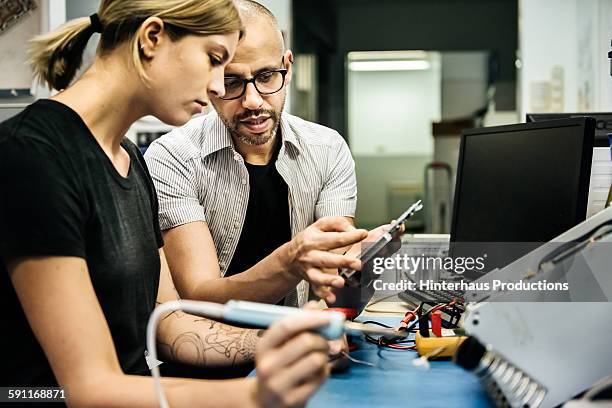 technician guiding female trainee in workshop - trainee imagens e fotografias de stock