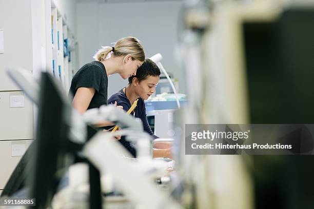 two female technicians in workshop - messa a fuoco differenziale foto e immagini stock