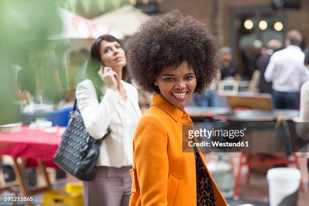 portrait of smiling woman in the city - orange jacket stock pictures, royalty-free photos & images