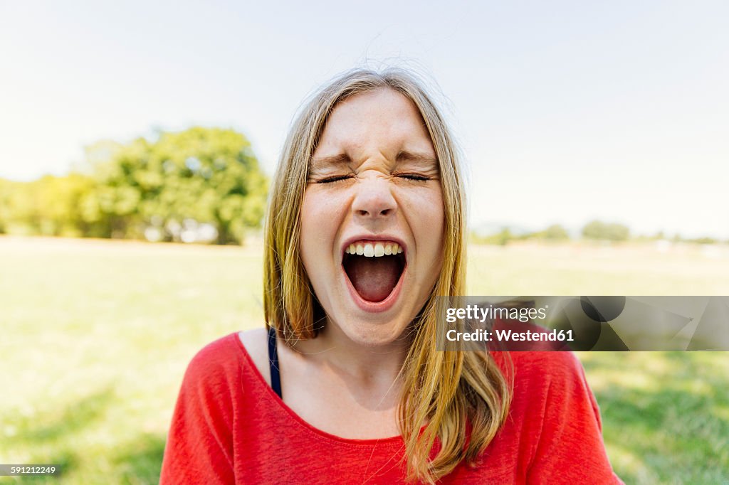 Portrait of teenage girl outdoors screaming