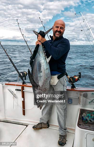 spain, asturias, fisherman holding freshly caught tuna - deep sea fishing stock pictures, royalty-free photos & images