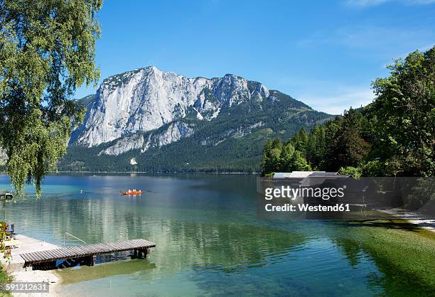austria, styria, altaussee, boat on lake with trisselwand at totes gebirge - styria stock-fotos und bilder