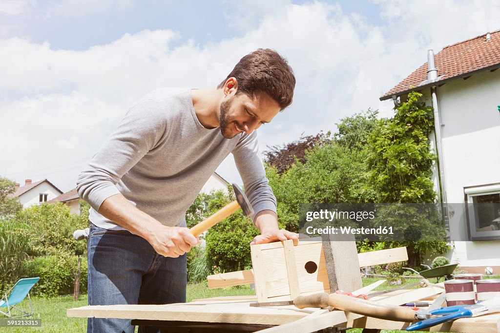 Man timbering a birdhouse