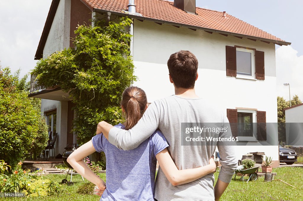 Couple in garden looking at residential house