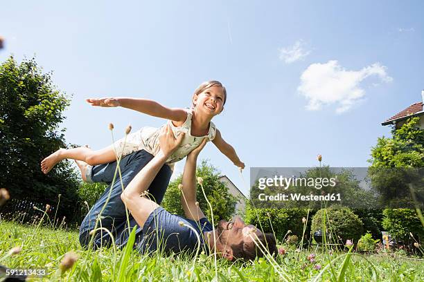 father playing with daughter in garden - 飛行機のまね ストックフォトと画像