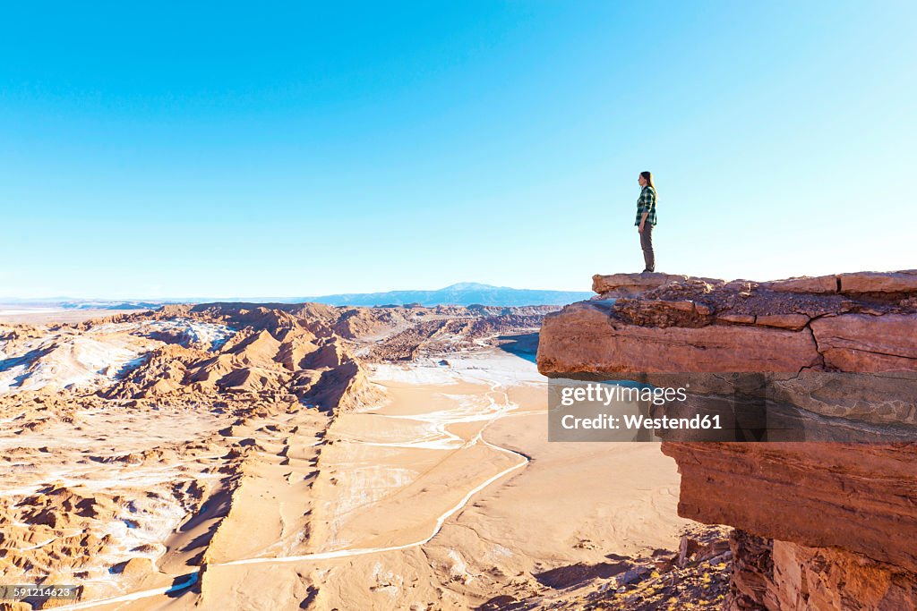 Chile, Atacama Desert, woman standing on a cliff looking at view