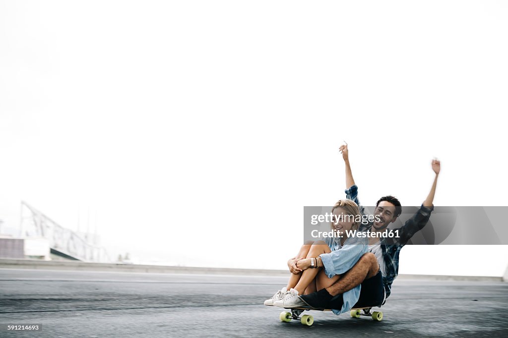 Young couple cruising on a longboard