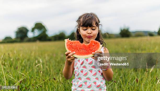 little girl eating watermelon - melone stock-fotos und bilder