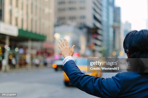 usa, new york city, businessman hailing a taxi - hail stock-fotos und bilder