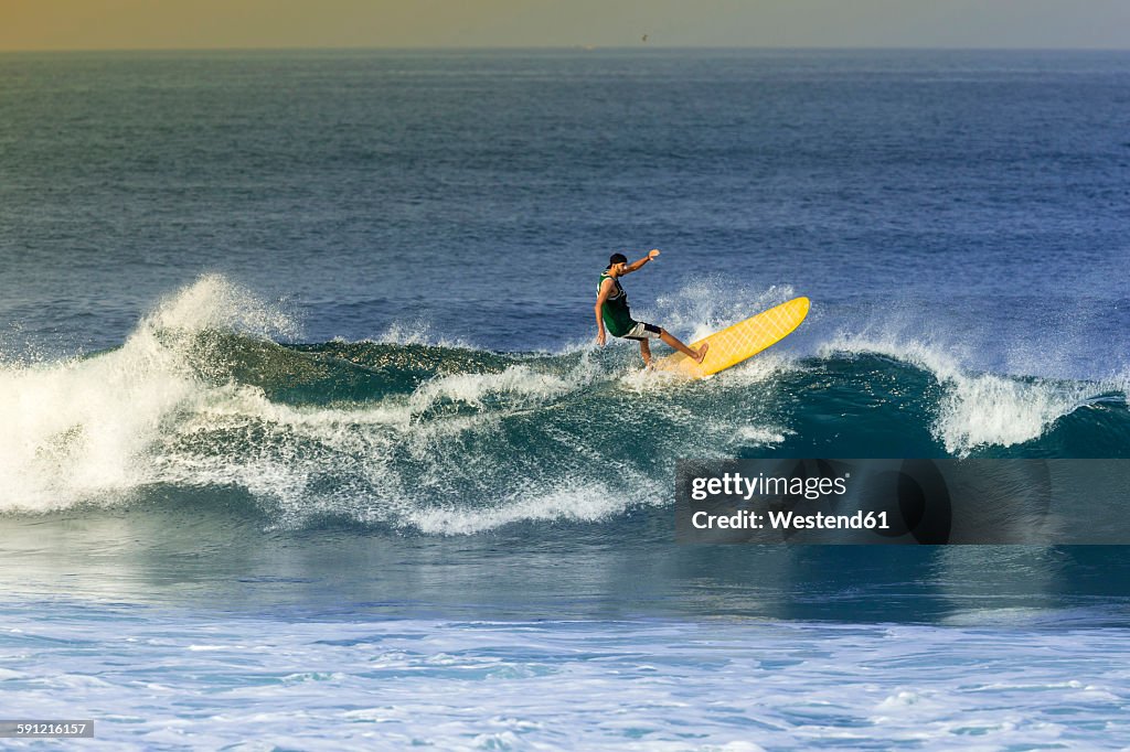 Indonesia, Bali, man surfing a wave