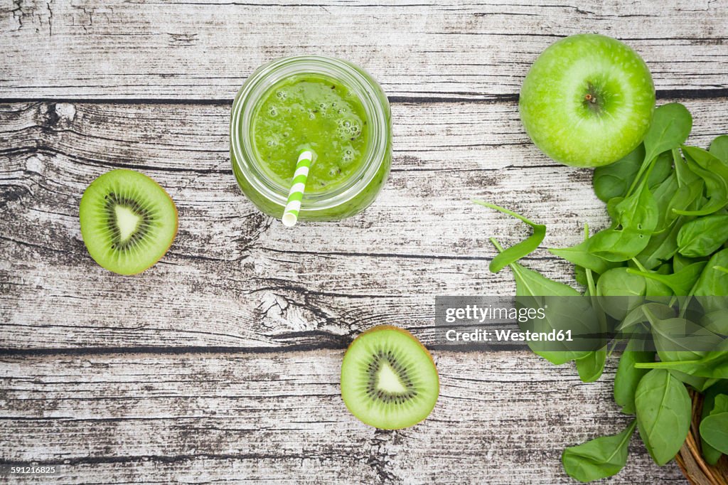 Glass of apple kiwi spinach smoothie and ingredients