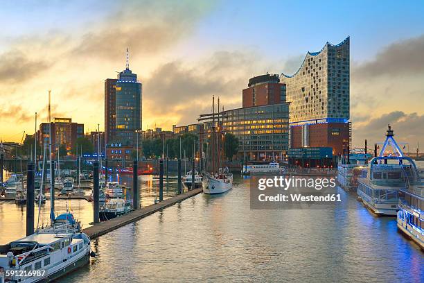 germany, harbour at sunrise, with elbphilharmonie and hanseatic trade center in background - elbphilharmonie hamburg foto e immagini stock