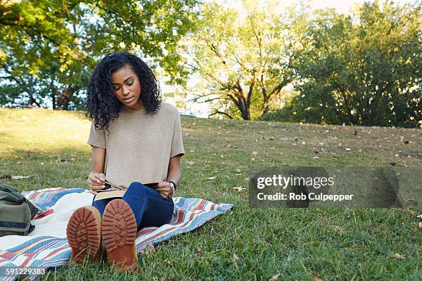 college student reading in a city park - mujer leyendo libro en el parque fotografías e imágenes de stock