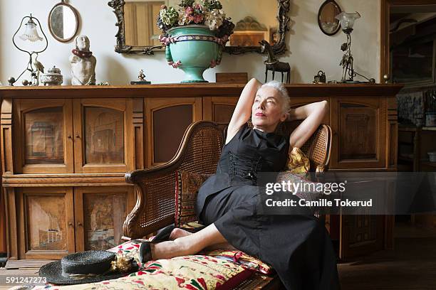 senior woman resting on antique chair thinking - antique sofa styles foto e immagini stock