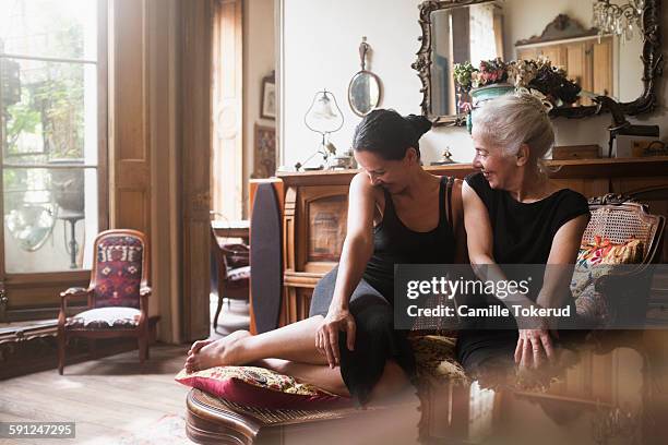 two fashionable women sharing time and smiling - antique sofa styles foto e immagini stock