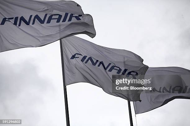 Branded flags fly outside the head office of Finnair Oyj at Helsinki-Vantaa airport in Helsinki, Finland, on Wednesday, Aug. 17, 2016. Finnair shares...