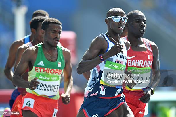 Britain's Mo Farah competes with Ethiopia's Hagos Gebrhiwet and Bahrain's Albert Kibichii Rop in the Men's 5000m Round 1 during the athletics event...
