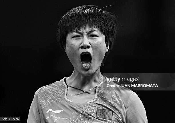 China's Ding Ning celebrates after a game against China's Li Xiaoxia in their women's singles final table tennis match at the Riocentro venue during...