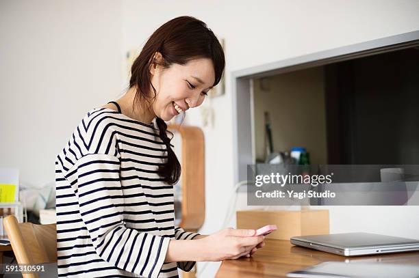woman using the smartphone in room - woman smiling facing down stock pictures, royalty-free photos & images