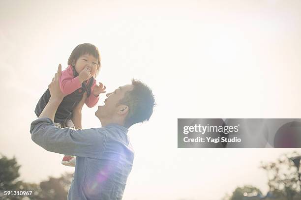 father holding daughter - één ouder stockfoto's en -beelden