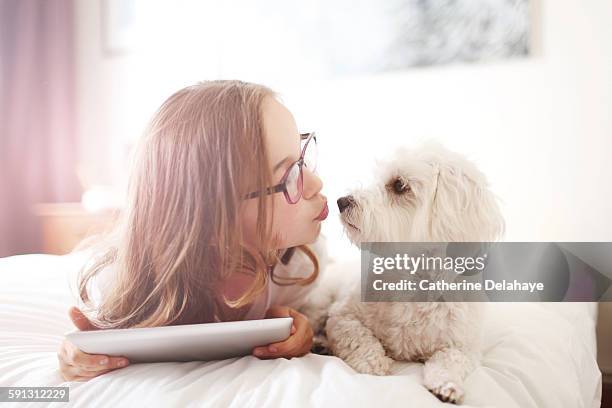 A 10 years old girl with her dog and a tablet