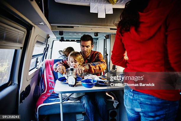 Family eating breakfast in camper van