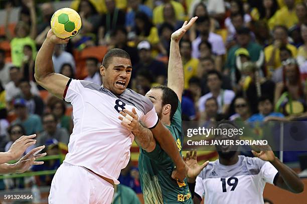 France's centre back Daniel Narcisse vies with Brazil's centre back Henrique Teixeira during the men's quarterfinal handball match Brazil vs France...