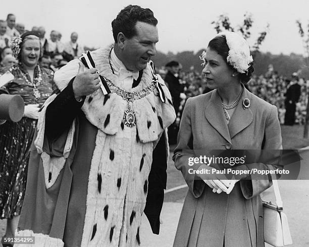 Queen Elizabeth II talks with the Lord Provost of Edinburgh, Sir James Miller, in front of a crowd of people at the Meadows near George Square in...