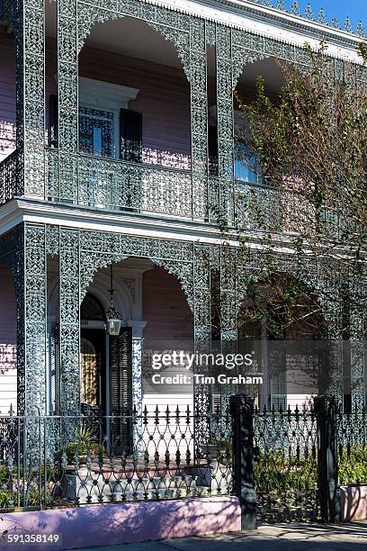 Grand mansion house with ornate lacy ironwork fretwork double gallery in the Garden District of New Orleans, Louisiana, USA