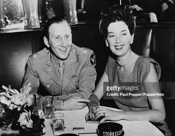 American actress Rosalind Russell pictured sitting with her husband Major Frederick Brisson at a dinner table together as they are reunited following...