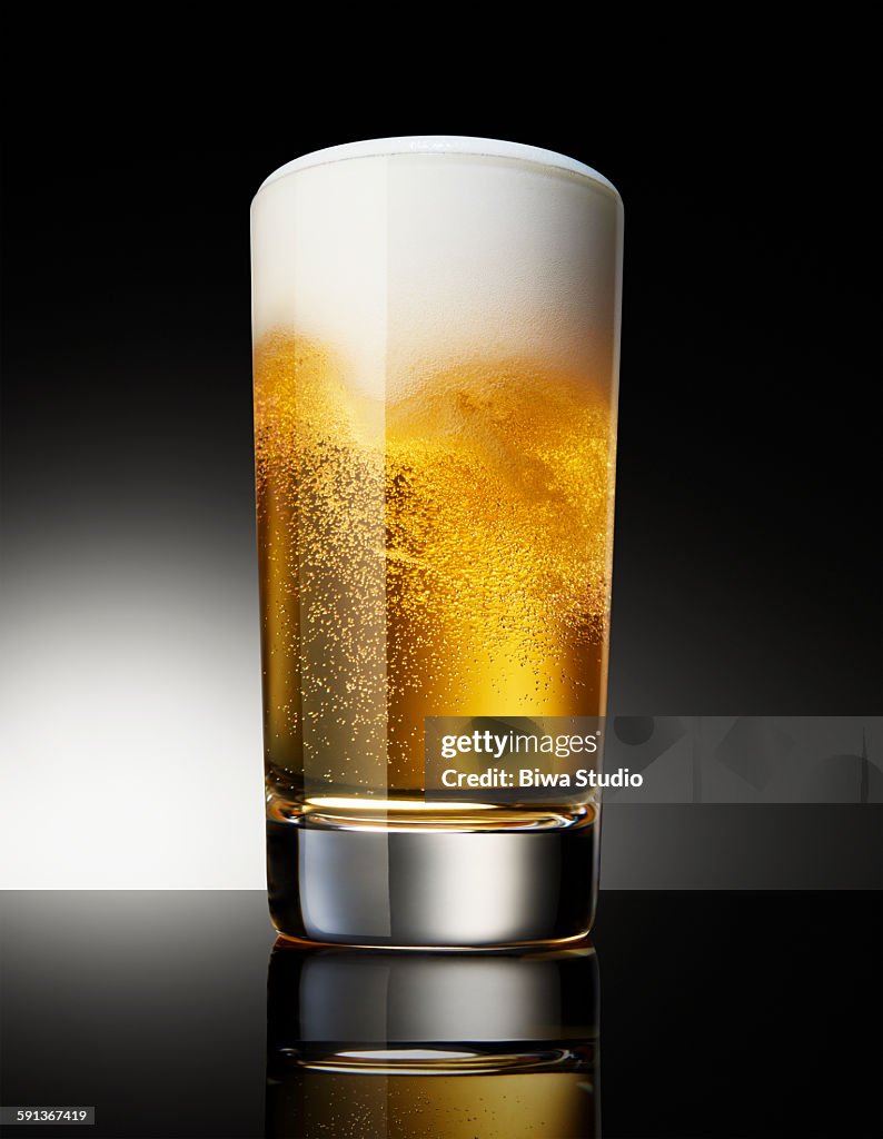 Beer in glass on black background