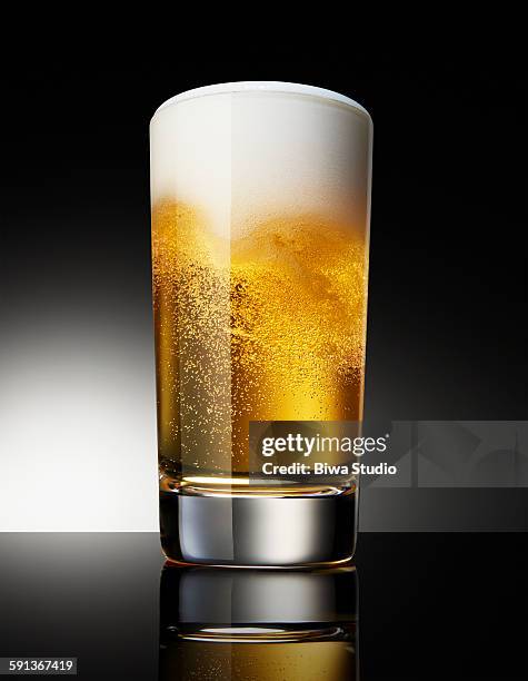beer in glass on black background - beer bubbles stock pictures, royalty-free photos & images