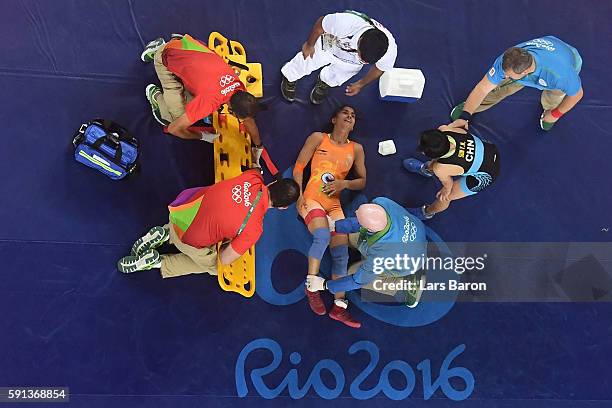 An injured Vinesh Vinesh of India is treated during a Women's Freestyle 48kg Quarterfinal bout against Yanan Sun of China on Day 12 of the Rio 2016...