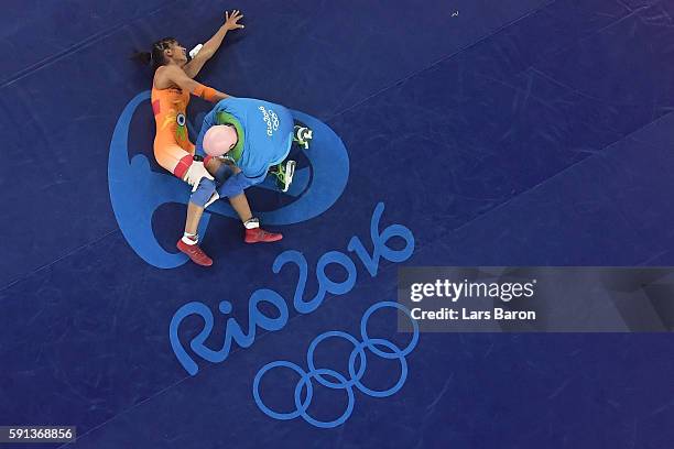 An injured Vinesh Vinesh of India is treated during a Women's Freestyle 48kg Quarterfinal bout against Yanan Sun of China on Day 12 of the Rio 2016...