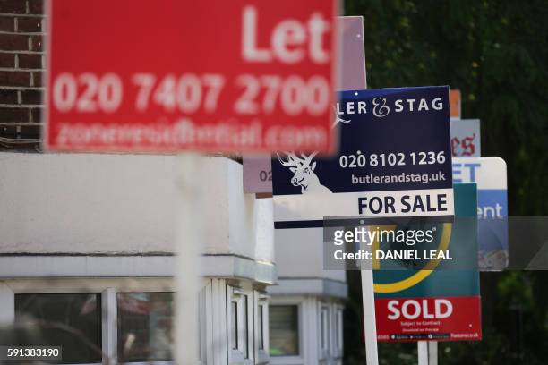 Estate agents placards are seen in front of houses in London on August 17, 2016 - From computers and cars to carpets and food, Britain's decision to...