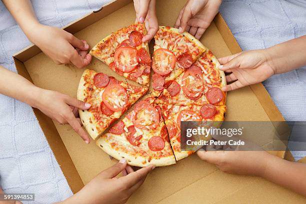 children's hands taking pizza slices out or box - pizza fotografías e imágenes de stock